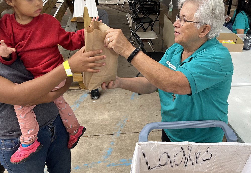 Notre Dame Sr. Joyce Bates serves lunch to migrants in La Frontera’s annex in Laredo, Texas. Before volunteering at La Frontera, Notre Dame Sr. Joyce Bates, originally from Toledo, Ohio, held ministries in education, children’s homes and nonprofit organizations, among others. (Luis Donaldo Gonzalez)