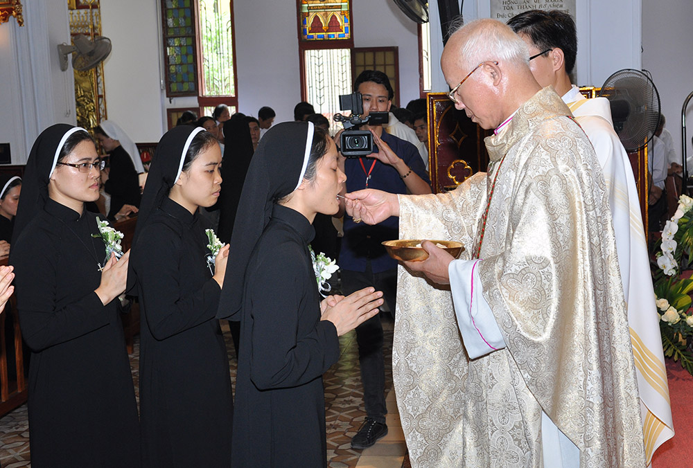 Lovers of the Holy Cross Sr. Ngoc Nguyen receives Communion at her first vows ceremony at St. Joseph's Cathedral in Hanoi, Vietnam, on Aug. 22, 2013. (Courtesy of the Lovers of the Holy Cross)