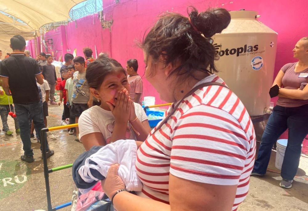 A migrant woman and her daughter were surprised to see money inside a wallet, a gift from women religious and their friends, who visited migrants at the Cobino shelter in Mexicali May 10. The visit was facilitated by the nonprofit Border Compassion, which organizes interfaith encounters with migrants. (GSR photo/Rhina Guidos)