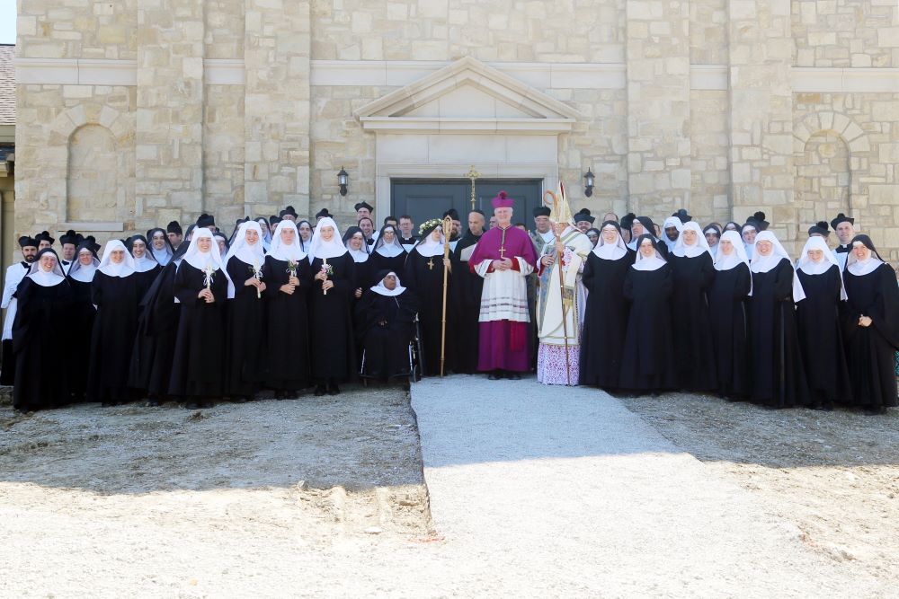All the sisters of the Benedictines of Mary, Queen of Apostles, order stand with attending priests and deacons after the consecration of Abbess Cecelia Snell Sept. 10, 2018, at the Abbey of Our Lady of Ephesus in Gower, Mo. In the center, from left to right, are Sister Wilhelmina Lancaster, the order's foundress; Abbess Snell; Abbot Phillip Anderson of Our Lady of Clear Creek Benedictine Abbey in Hulbert, Okla.; Bishop James V. Johnston Jr. of Kansas City-St. Joseph, Mo.; and Bishop Robert G. Morlino of Mad