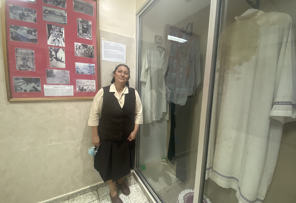 Sr. Ruby Lemus Salguero stands next to a case that holds the bloodstained relics of St. Oscar Romero March 24, on the grounds of the Divine Providence Hospital in San Salvador, El Salvador. Among the relics is the habit of a nun, one of the Missionary Carmelites of St. Teresa, who ran to Romero's side after he was fatally shot and whose dress absorbed some of the martyr’s blood. (GSR photo/Rhina Guidos)