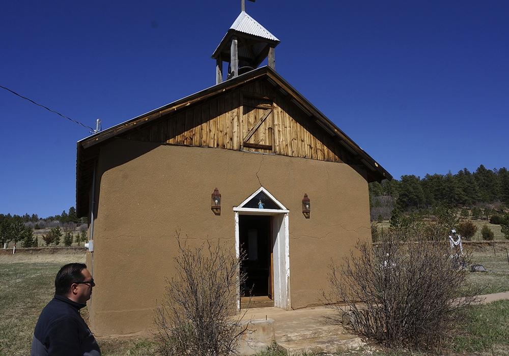 Fidel Trujillo stands outside the Santo Nino de Atocha Church in the remote mountain hamlet of Monte Aplanado, New Mexico, April 15. Trujillo serves as "mayordomo" or caretaker for a nearby church, also made in adobe — the sand, dirt and straw mix with which Catholic churches have been built here since the area was a remote outpost of the Spanish empire four centuries ago. (AP Photo/Giovanna Dell'Orto)