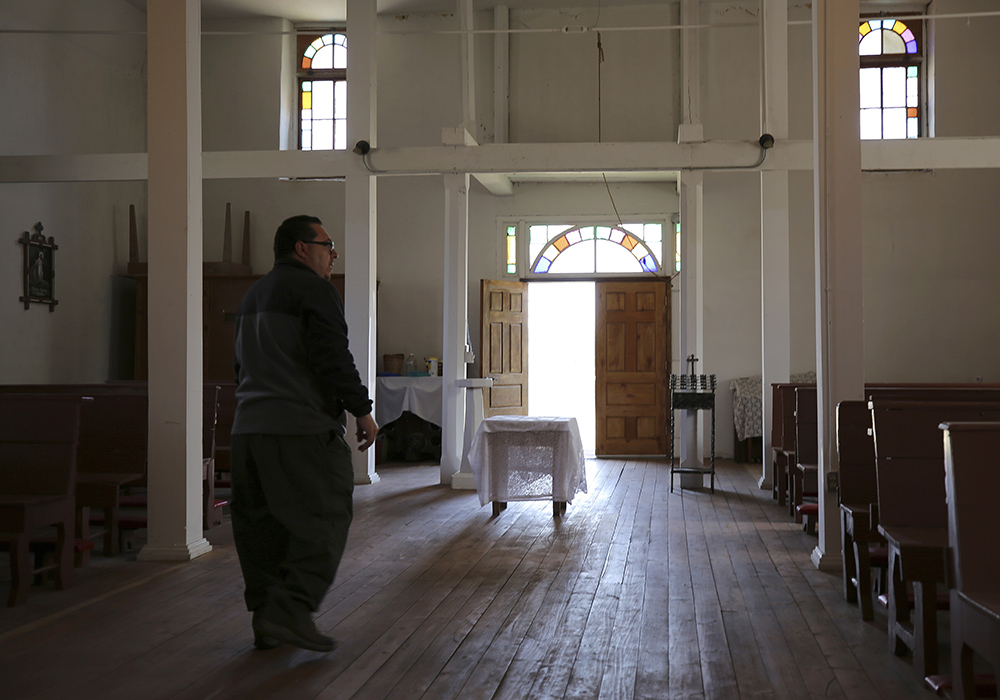 Fidel Trujillo walks inside the San Jose chapel in the hamlet of Ledoux, New Mexico, April 15. Last spring's massive wildfire charred trees less than 100 yards from the church, for which Trujillo and his wife serve as mayordomos, or caretakers, keeping it spotless even though it's seldom used for services. (AP photo/Giovanna Dell'Orto)
