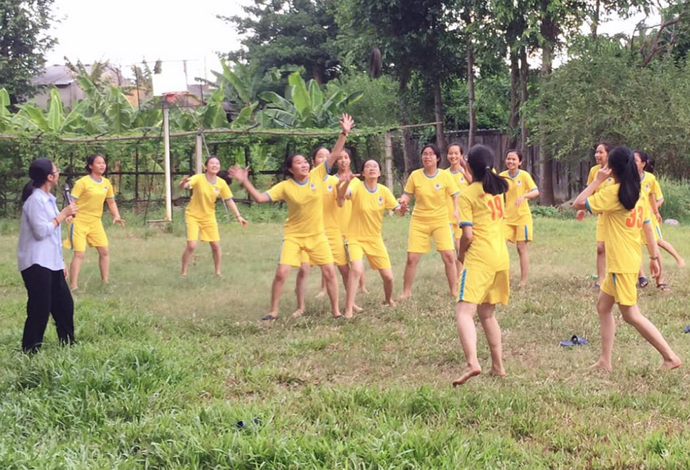 Young women play a game on April 23 in the compound of the motherhouse of the Daughters of Our Lady of the Visitation in Hue, Vietnam. They regularly gather to study the Bible, attend Eucharist adoration, play games, and have meals as a way to find joy and solidarity in consecrated life. (Joachim Pham)