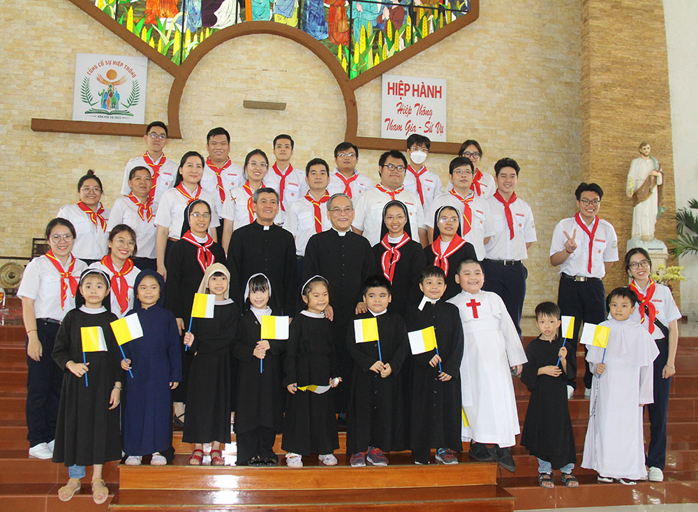 Children in religious habits and Vatican flags in hand, joined by three Lovers of the Holy Cross nuns, Fr. John Le Quang Viet (right), his assistant priest, and catechists pose for a photo in Dong Tien Church to mark World Vocations Day in Ho Chi Minh City, Vietnam, April 30. Some 200 catechism students and catechists attended the celebration and learned some congregations' spiritualities. (Joachim Pham)