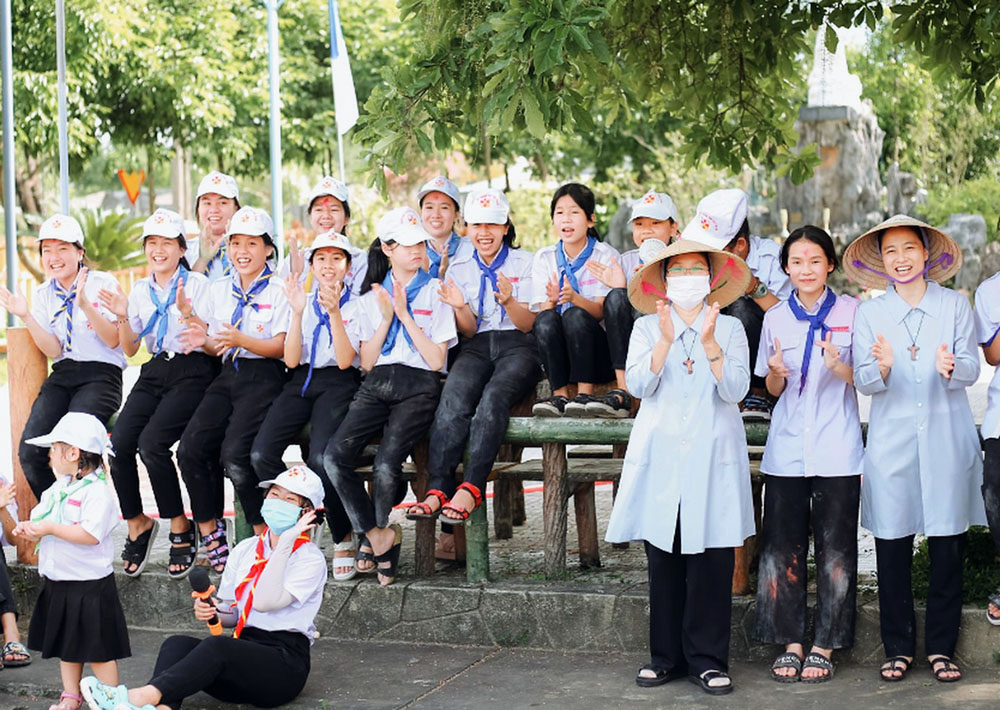Filles de Marie Immaculée Srs. Mary Elizabeth Tran Thi Bich Diep (first from right) and Mary Vu Thi Thuy Anh (third from right) spark young women's interests in religious vocations by playing outdoor games with them at Xuan Thien Parish in Hue, Vietnam, April 23.