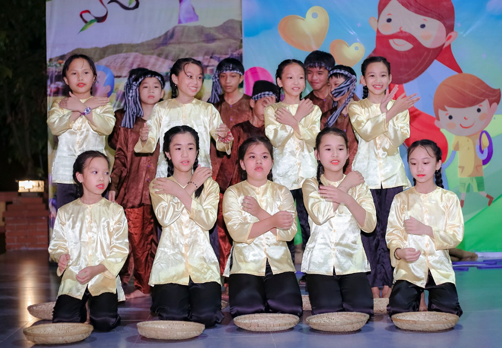 Children in traditional costumes give cultural performances of daily activities at schools, hospitals and factories done by members of Tu Hoi Doi Nu Tro Ta Tin Mung, a secular institute based in Hue, Vietnam. The event was held April 27 at Loc Tien Church by the vocation promotion committee of the Women Orders Association. St. Paul de Chartres Sr. Lucia Ho Thi Thuy said the institute with 46 members last year had only two newcomers, but in previous years welcomed five to 10. (Joachim Pham)