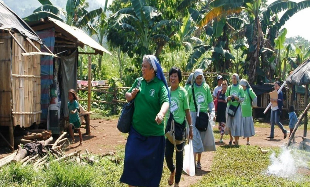 Sisters from different congregations who are part of the Rural Missionaries of the Philippines make home visits with villagers. (Courtesy of Rural Missionaries of the Philippines)