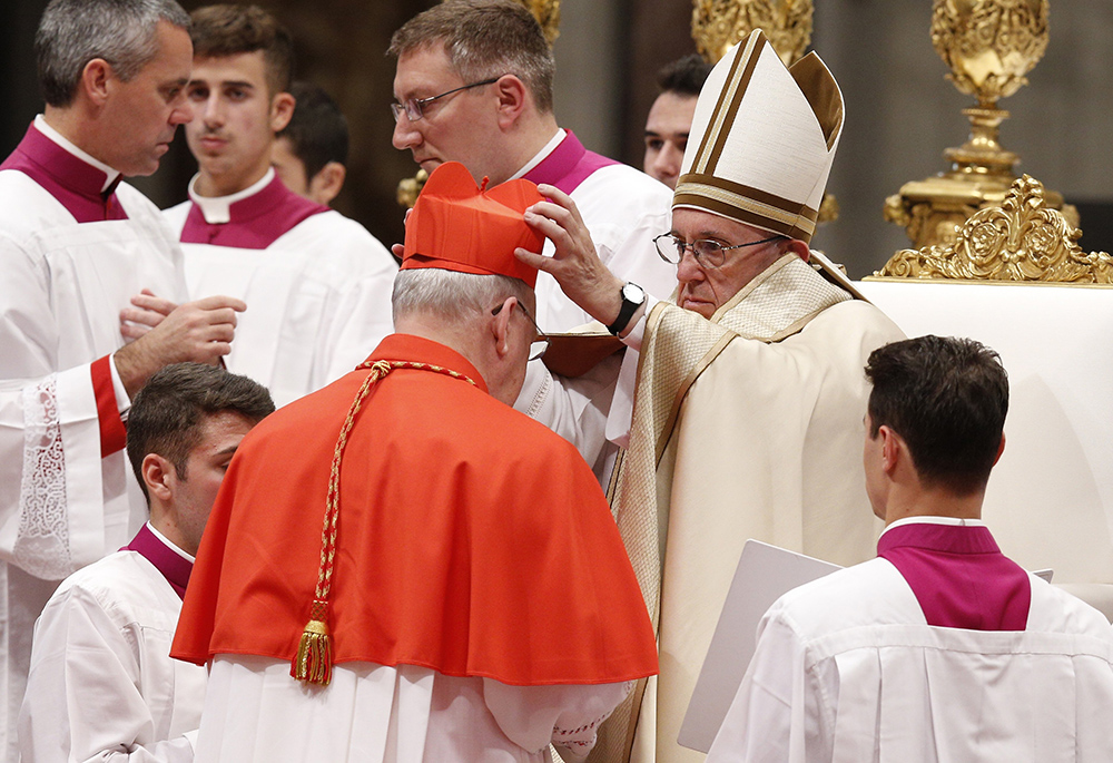Pope Francis places a red biretta on then-new U.S. Cardinal Kevin Farrell during a consistory in St. Peter's Basilica at the Vatican in this Nov. 19, 2016, file photo. (CNS/Paul Haring)