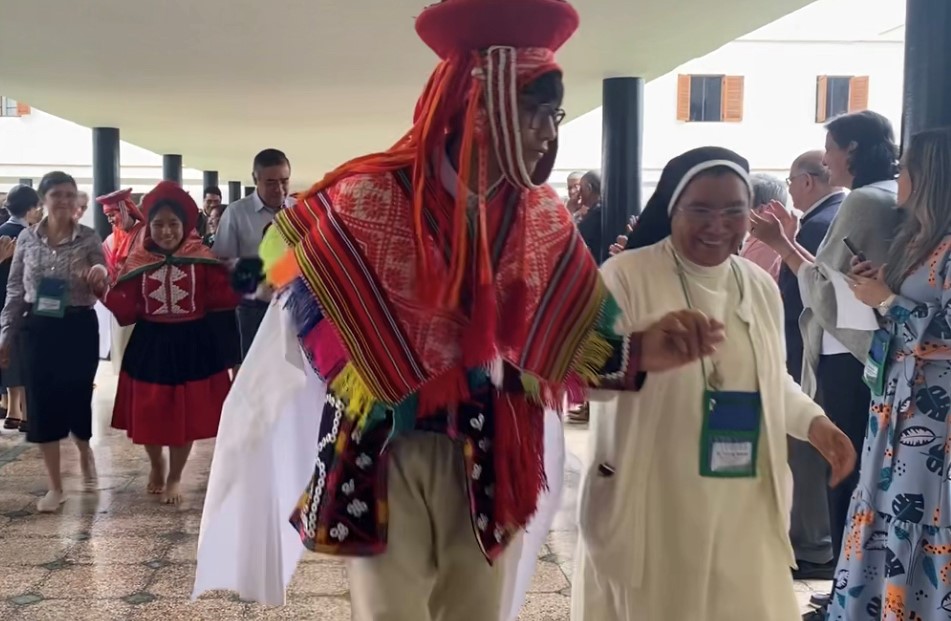Un bailarín del Colegio Fe y Alegría acompaña a la Hna. Silvia Flores, derecha, a la reunión de apertura de la junta directiva de la Confederación Latinoamericana de Religiosos el 2 de junio, en Lima, Perú.