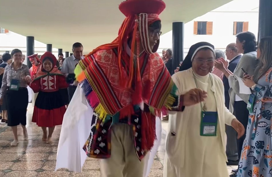 A dancer from the Fe y Alegria School escorts Sr. Silvia Flores, right, to the opening of the board meeting of the Confederation of Latin American and Caribbean Religious June 2, in Lima, Peru.