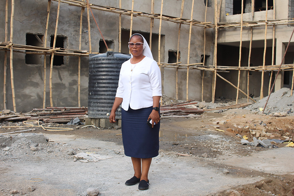Holy Child Jesus Sr. Assumpta Ndidiamaka Okoli poses for a photo on the site of a new hospital building. (Valentine Benjamin)