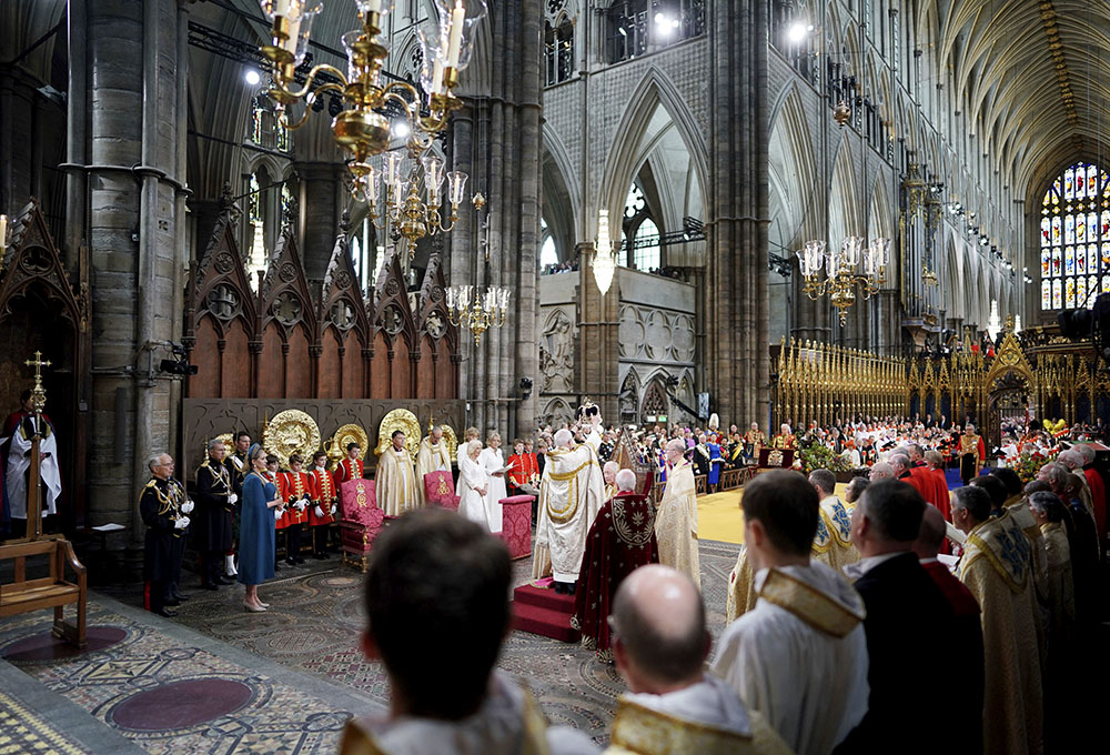 King Charles III sits as he is crowned with St. Edward's Crown by Archbishop of Canterbury Justin Welby during the coronation ceremony at Westminster Abbey, London, May 6. (Jonathan Brady/Pool Photo via AP)