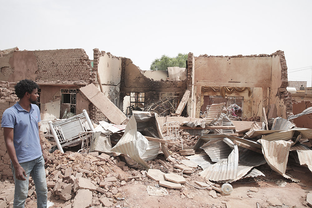 A man walks by a house hit in fighting between the Sudanese Armed Forces and the Rapid Support Forces in Khartoum, Sudan, on April 25. (AP/Marwan Ali)