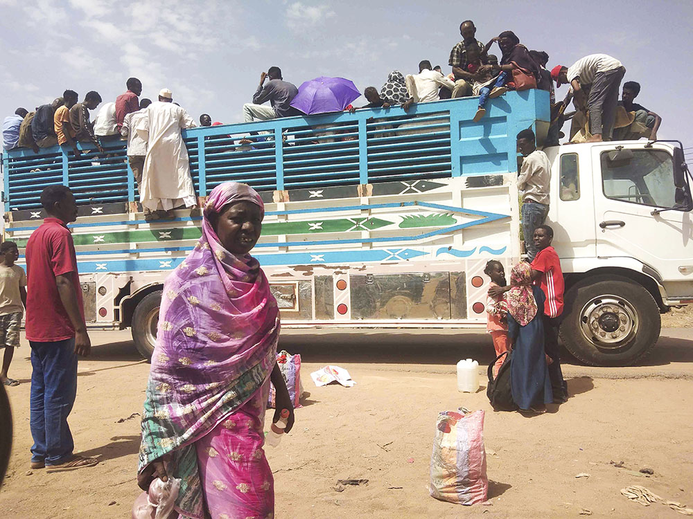 People board a truck as they leave Khartoum, Sudan, on June 19. Clashes resumed between Sudan's military and a powerful paramilitary force after a three-day cease-fire expired June 21. (AP, file)