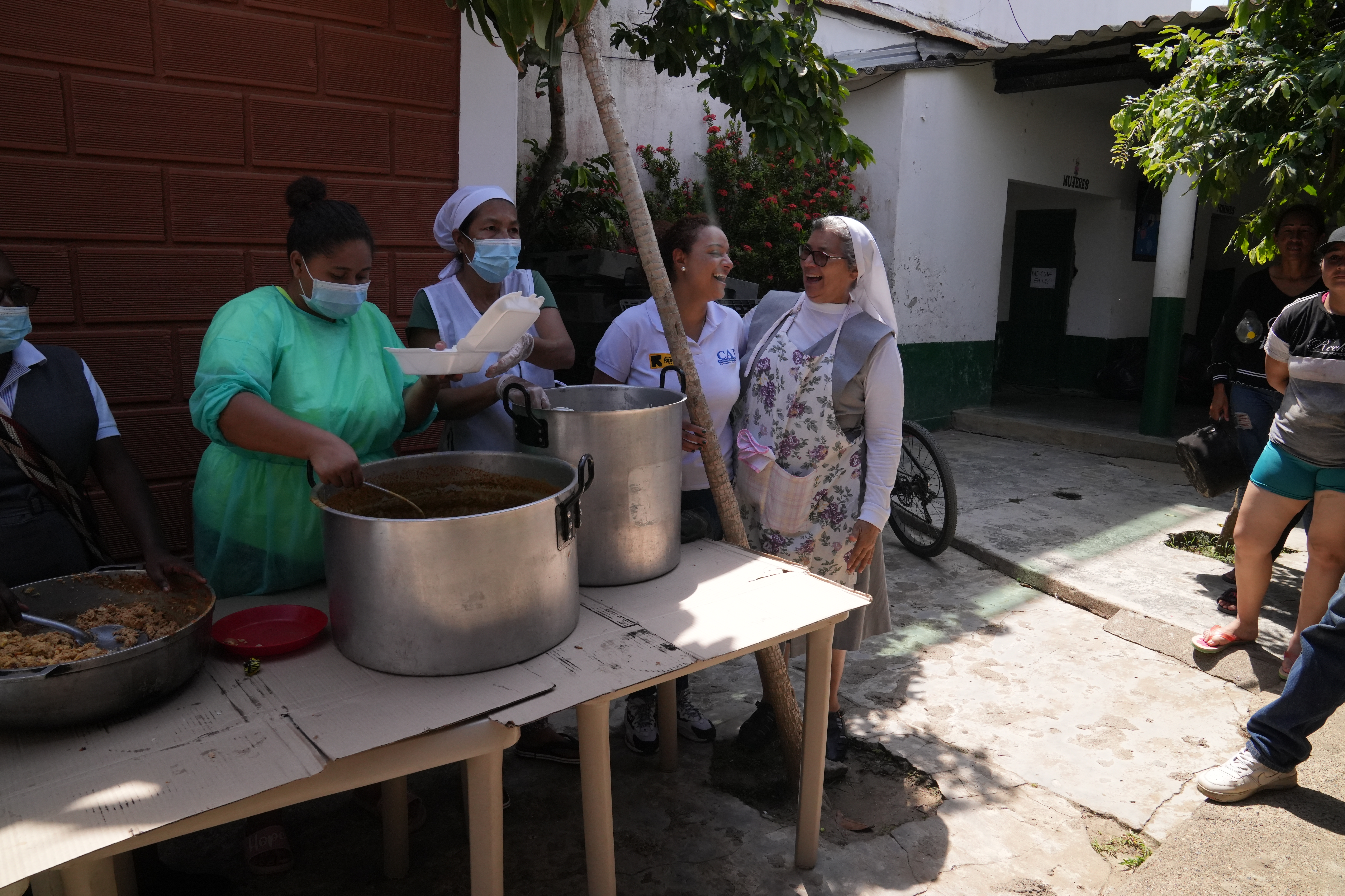 La Hna. Juliana Plata, de San Juan Evangelista, charla con voluntarios en el centro comunitario de Necoclí, Colombia, donde las monjas ofrecen comidas gratuitas a los inmigrantes, todos los días; además de orientación sobre el viaje a través de la selva. (Foto: GSR/Manuel Rueda)