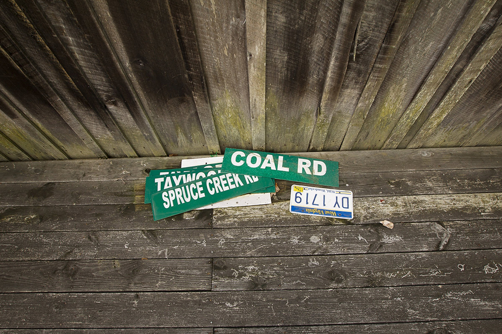 Road signs lay on the side porch of a house near Kermit, West Virginia, Aug. 20, 2014. (CNS/Tyler Orsburn)
