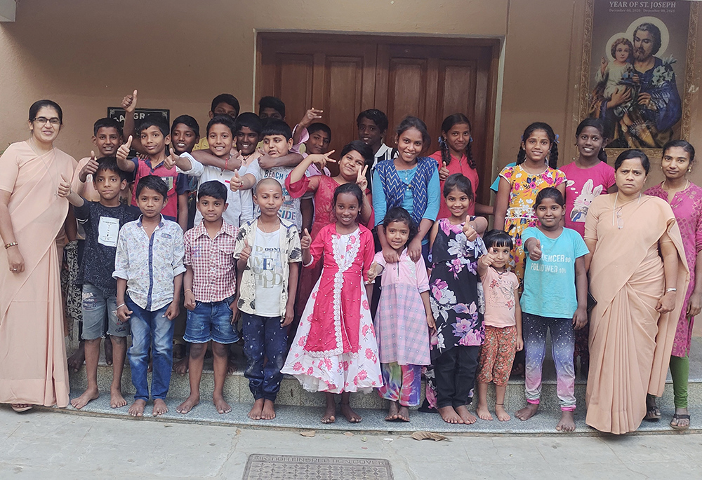Children get ready to sing "happy birthday" to Priya Raj (far right), a resident in Sangraha, a shelter home managed by the St. Joseph of Tarbes congregation in the southern Indian city of Bengaluru. Sister Mariamma (front left) and Sr. Irudaya Mary (front right) pose with children. (Thomas Scaria)