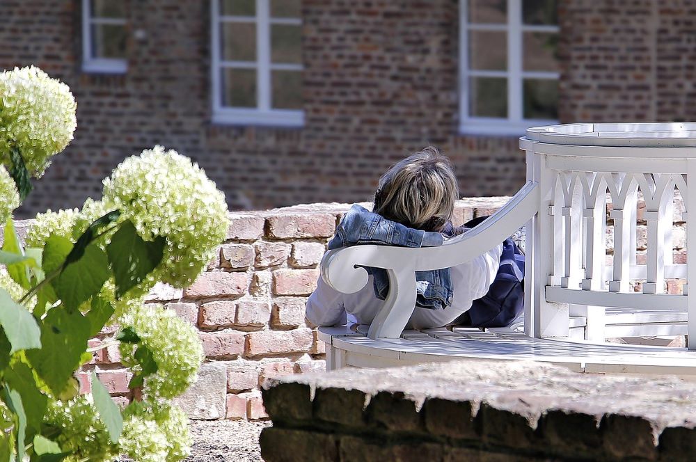 A person relaxes on a chair in a garden.