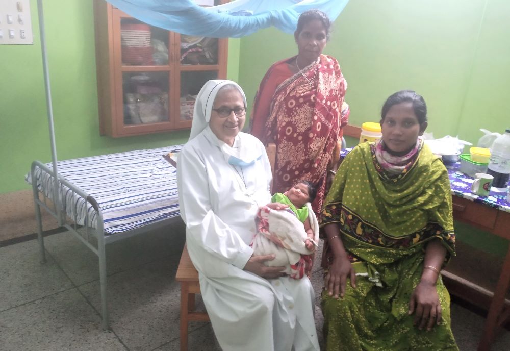 Sr. Sandra Joseph, a member of Sisters of Charity of Sts. Bartolomea Capitanio and Vincenza Gerosa, visits a newborn baby and their relatives at St. Vincent Hospital in Dinajpur, Bangladesh, where she has ministered for 42 years. (Sumon Corraya)