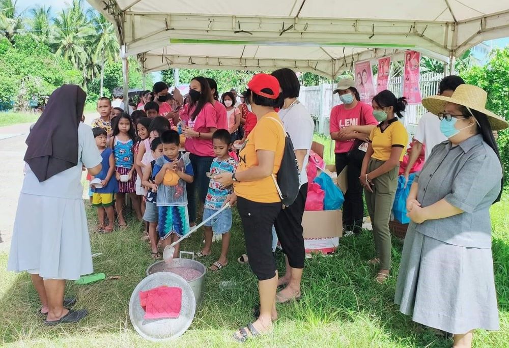 The community health workers, Philberth Foundation scholars, and the two sisters sponsored a meal for the children they serve in the Philippines. (Courtesy of Edita Eslopor)