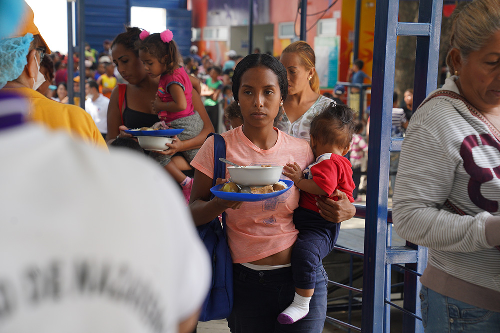 A Venezuelan migrant and her child receive a meal at the Divine Providence Food Pantry in Cucuta, Colombia, Jan. 31, 2020. (CNS/Manuel Rueda)