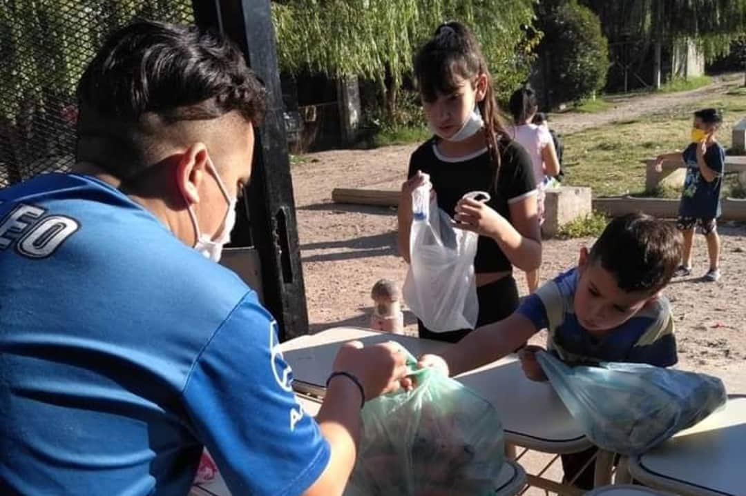 Leo, uno de los jóvenes, sirve la merienda a las puertas de la parroquia de la Virgen de la Asunción durante el tiempo de pandemia. (Foto: cortesía María A. Leguizamón)