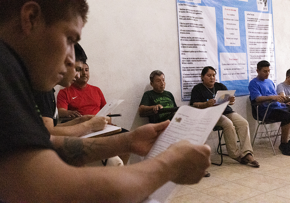 Casa Guerrero drug rehabilitation center patient, Fausto Andrés Tomas, left, goes over a handout as Sr. Sandra López García, third from right, leads an exercise during one of her weekly visits in Guadalupe, Mexico, on the edge of Monterrey. (Nuri Vallbona)