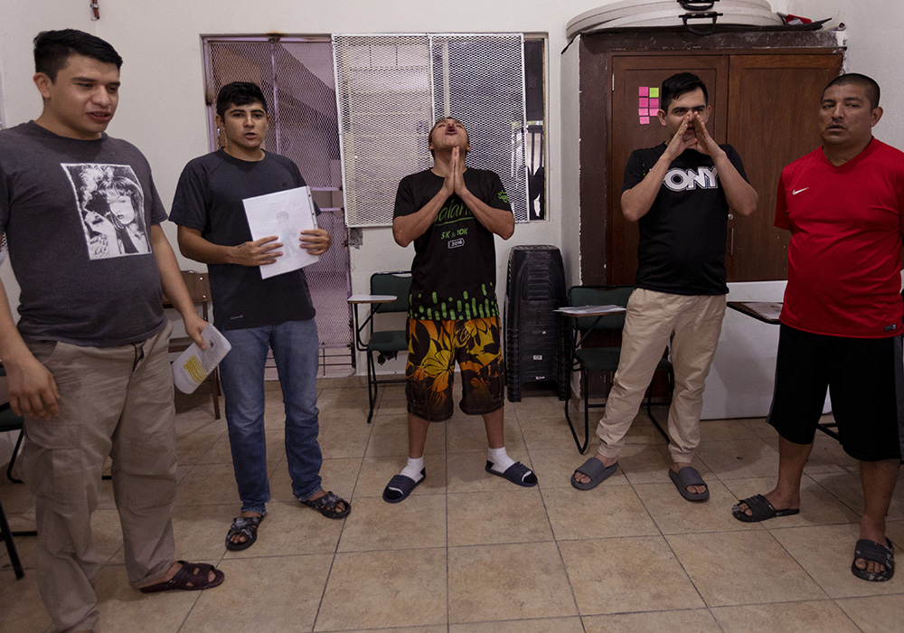 Casa Guerrero drug rehabilitation patients Josué Martínez Botaro, from left, Brian Garza, Fausto Andrés Tomas, Efraín Chavana and Eric Montoya shout out acclamations to cap off a visit by Sr. Sandra López García in Guadalupe, Mexico, on the edge of Monterrey, in May. (Nuri Vallbona)