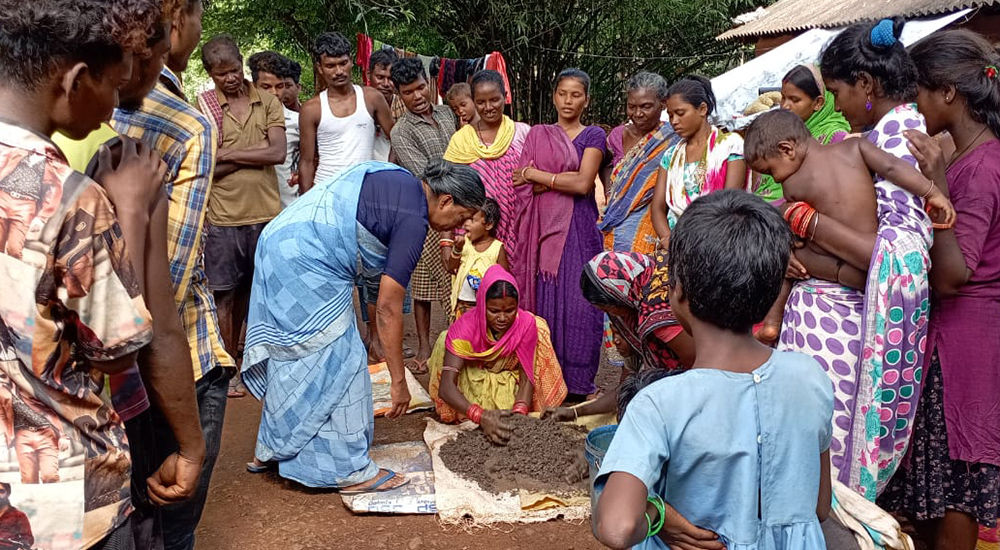 Sister Lisha demonstrates the method of organic manure composition to villagers. (Courtesy of Tessy Jacob)