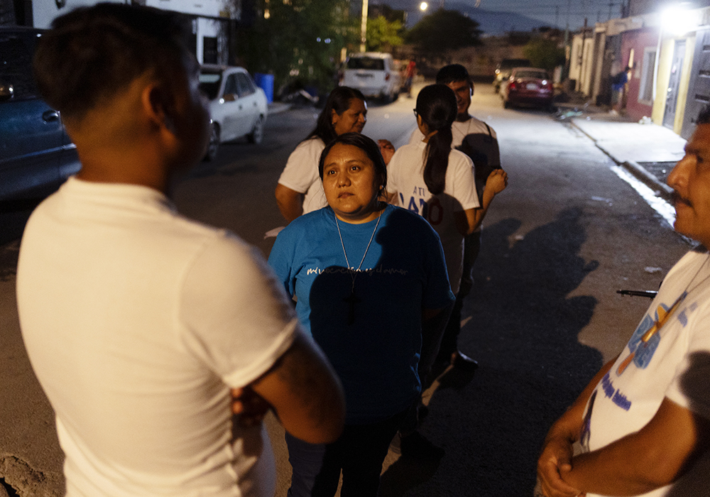 Sr. Sandra López García listens to Los Monckis member Fernando Barrientos talk about his newborn son, Liam, during one of her weekly visits to the youth gang's hangout in Monterrey, Mexico. (Nuri Vallbona)