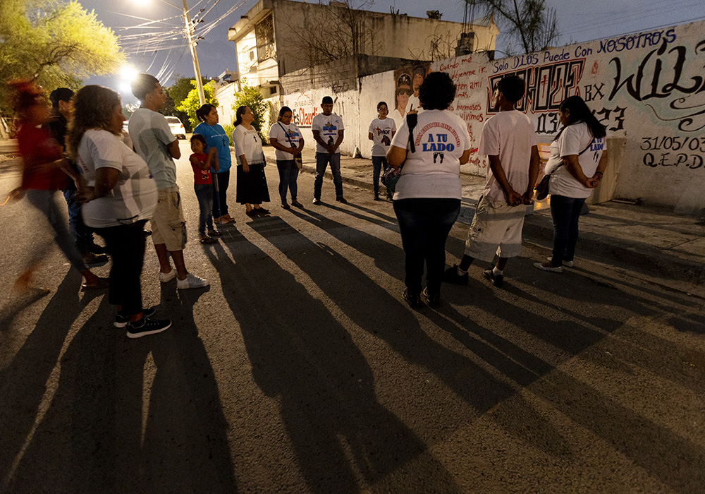 Sr. Sándy López García, Sr. Sanjuana Morales Nájera and lay missionaries pray in front of a memorial dedicated to two members of the Los Bronx youth gang who recently died in a motorcycle accident. (GSR photo/Nuri Vallbona)