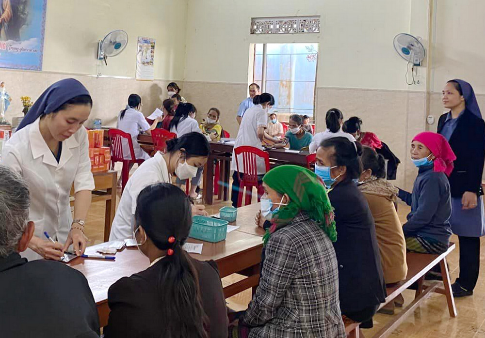 Lovers of the Holy Cross of Hue Sr. Agnes Duong Thi Phu (left) shows ethnic patients how to take medicines in Huong Hoa district. (GSR photo/Joachim Pham)