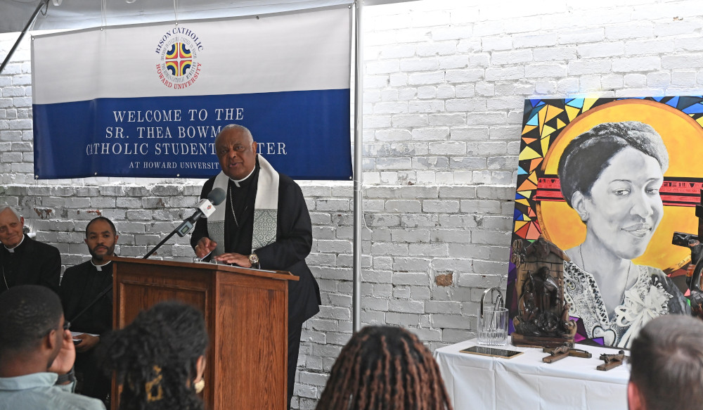 Cardinal Wilton Gregory speaks at a lecturn next to a painted portrait of Sister Thea Bowman
