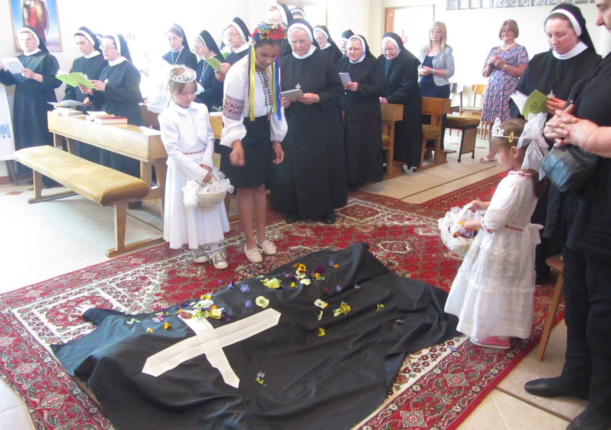 In a Byzantine Rite tradition, Sr. Teodozija Mostepaniuk is covered with a black cloth as a symbol of her death to the world as she makes her final profession as a Sister of the Order of St. Basil the Great (Province of St. Michael the Archangel, Croatia), placing her hand on the Gospel on April 29, 2018, in Osijek, Croatia. (Courtesy of Teodozija Mostepaniuk)