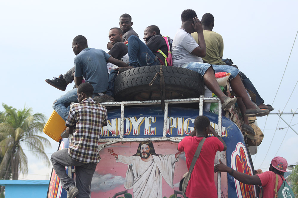 A typical scene in Haiti – men catching a ride on the back of an overcrowded bus. This 2017 photograph was taken on the road connecting the capital of Port-au-Prince with the southern coastal city of Jacmel. (GSR photo/Chris Herlinger)