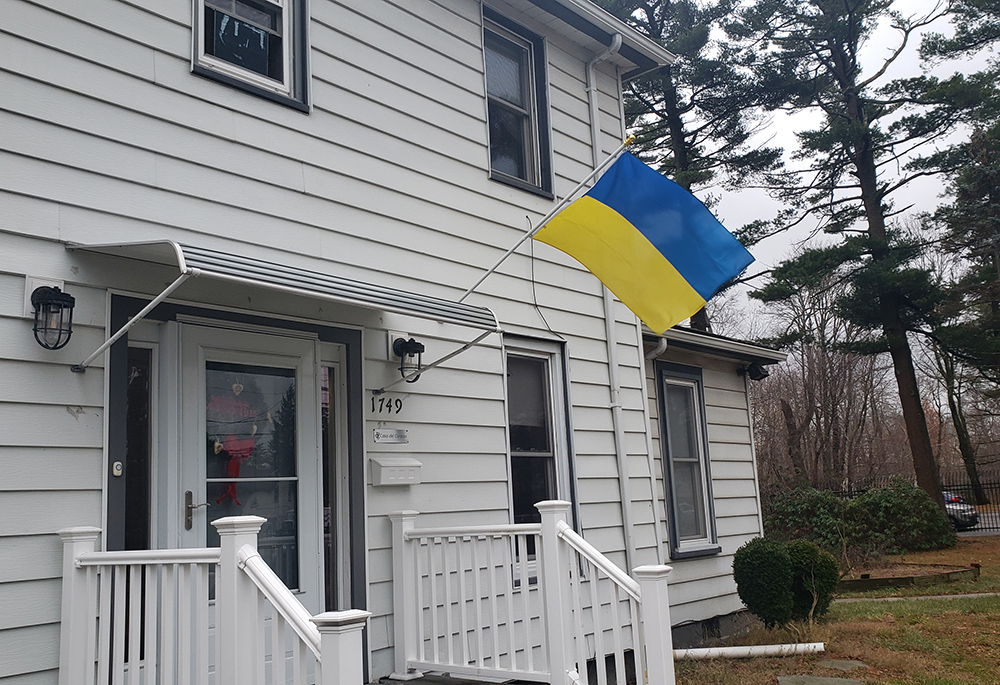 A Ukrainian flag flies outside a house on the campus of the Sisters of St. Joseph of Brentwood, New York, where two Ukrainian families resided. The house now flies an Afghanistan flag in front where Afghan families live, along with Srs. Karen Burke and Clara Santoro. (GSR photo/Chris Herlinger)
