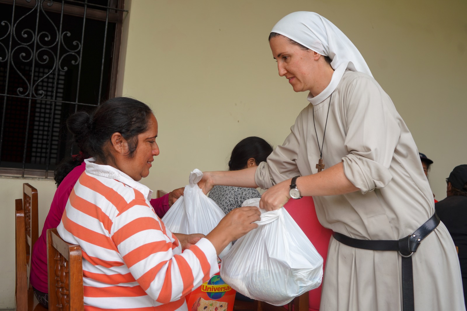 La hermana Begoña Costilllo entrega una bolsa de comida en las jornadas celebradas en el Monasterio de la Encarnación, en Lima, Perú. (Fotos: Laura Miyagui y Marlene Quispe)