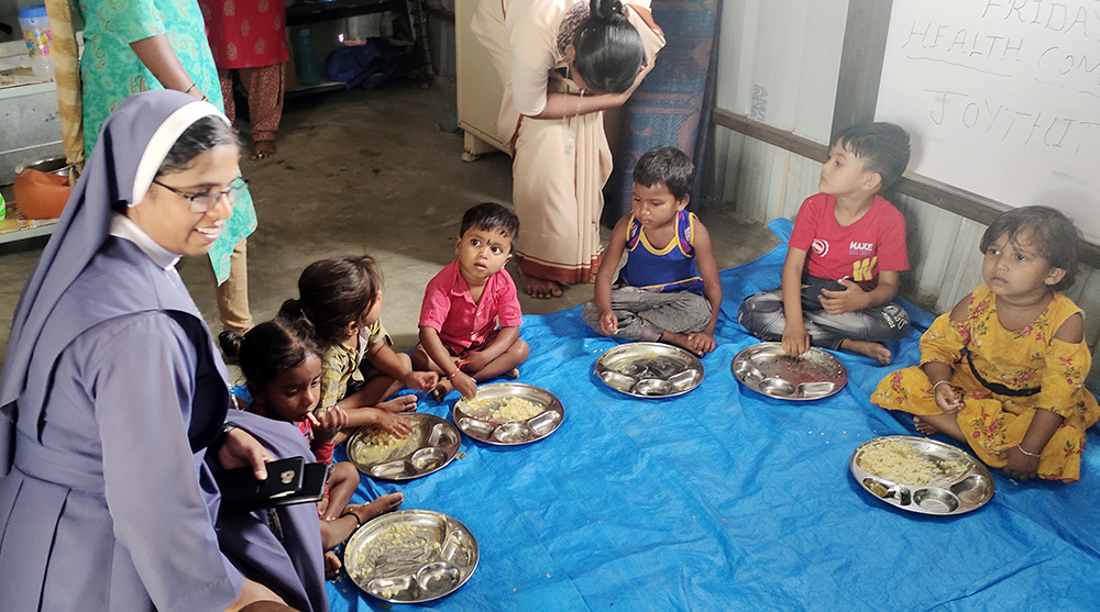 Poor Handmaids of Jesus Christ Sr. Bindu Jose, who directs Ashalaya, feeds some children of migrant workers at the nuns' early learning center in Jyothinagar, on the outskirts of Bengaluru city in southern India. (GSR photo/Thomas Scaria)