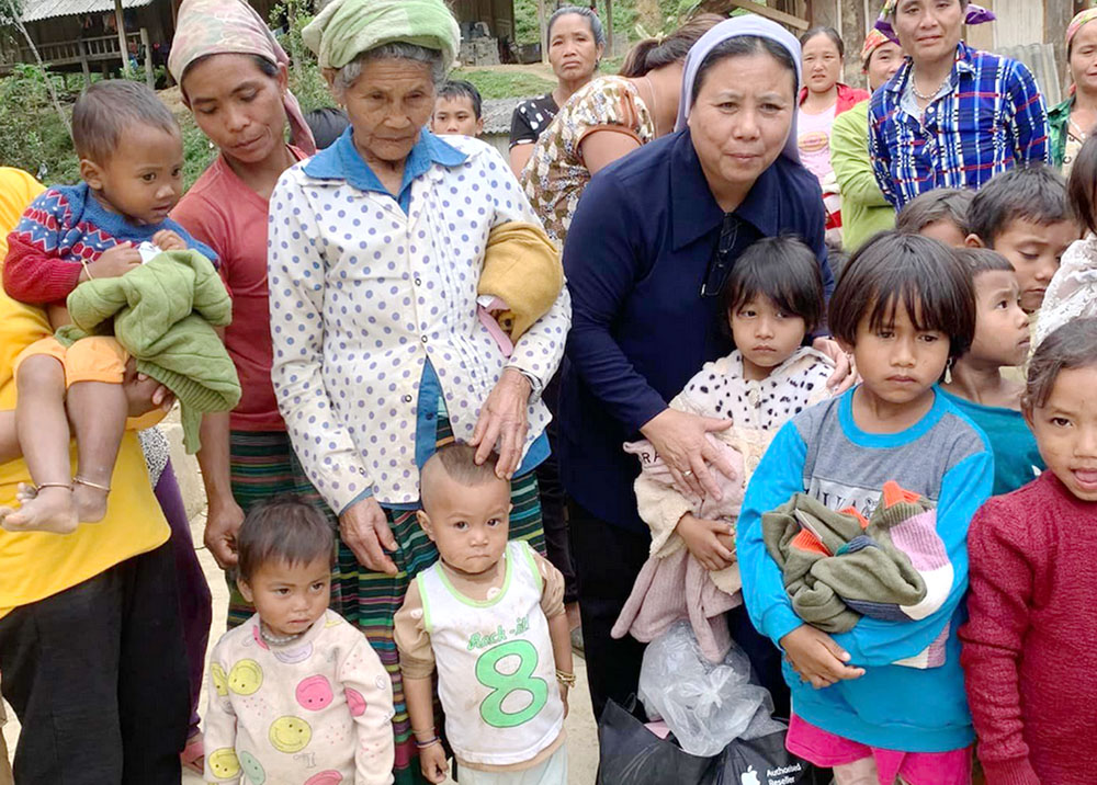 Missionaries of Charity Sr. Mary Teresa Dau Thi Tham gives warm clothes to ethnic children at a mission station in Quang Tri province Sept. 24. "They need warm clothes to survive the coming winter rather than sweets and lanterns," she said. (GSR photo/Joachim Pham)