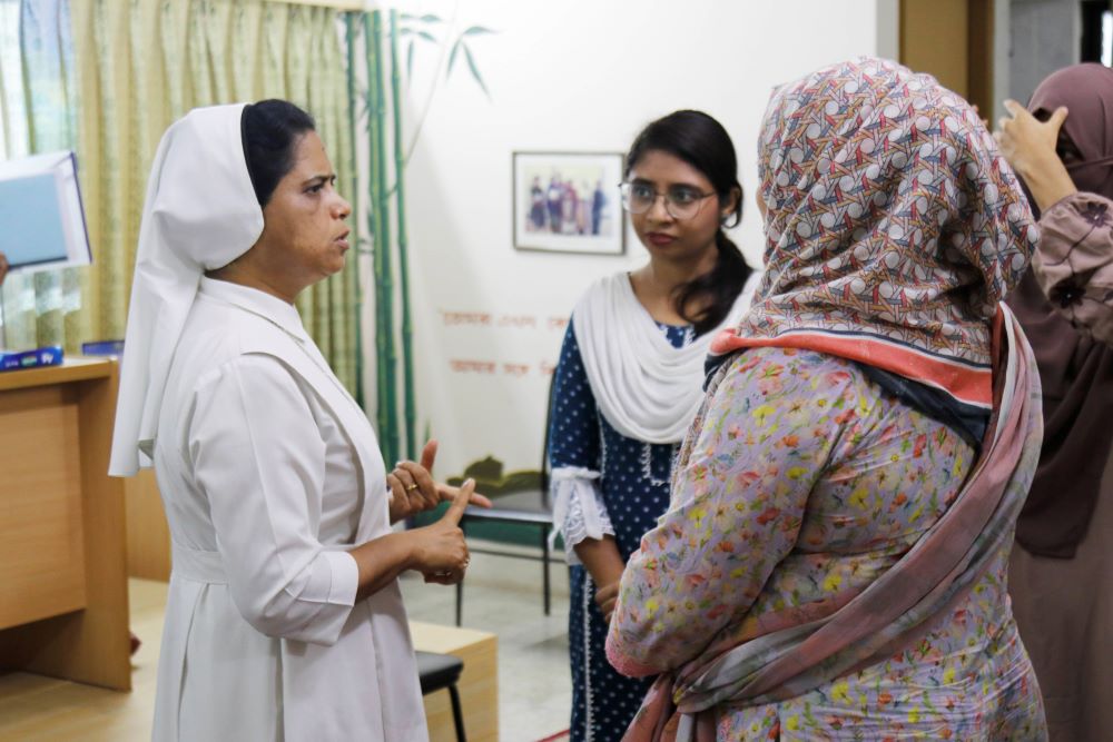 Sr. Gloria Rozario talks to two women 