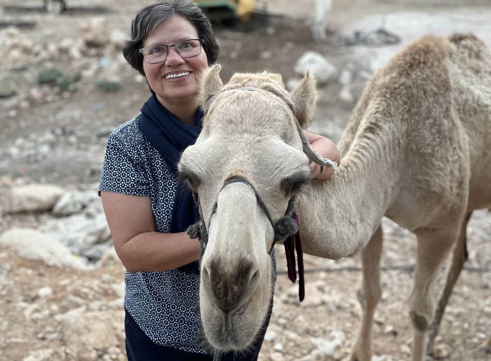 La hermana Julia Hurtado, con un camello en el desierto de Judea. Desde octubre de 2022 atiende a la población de los campamentos beduinos (Foto: cortesía Julia Hurtado)