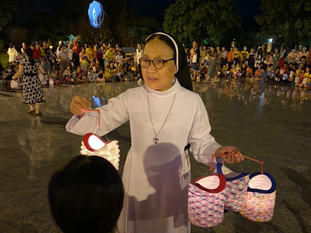 Dominican Sr. Anna Pauline Ngo Thi Ngo and 20 volunteers from Dong Nai province offer lanterns to 700 children in front of Tra Ke Church in Binh Dinh province Sept. 29. They sang songs, dance and enjoy food around a campfire at night. "We try to do something useful for children in rural areas to have an air of festivity," Ngo said. (Courtesy of Anna Pauline Ngo Thi Ngo)