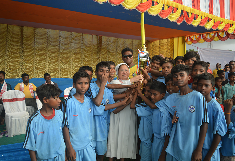 Missionary Sisters of Mary Help of Christians Sr. Rose Paite is pictured with children rescued from human traffickers, with a trophy they won at a local event in Guwahati, Assam, northeastern India. (Courtesy of Sr. Rose Paite)