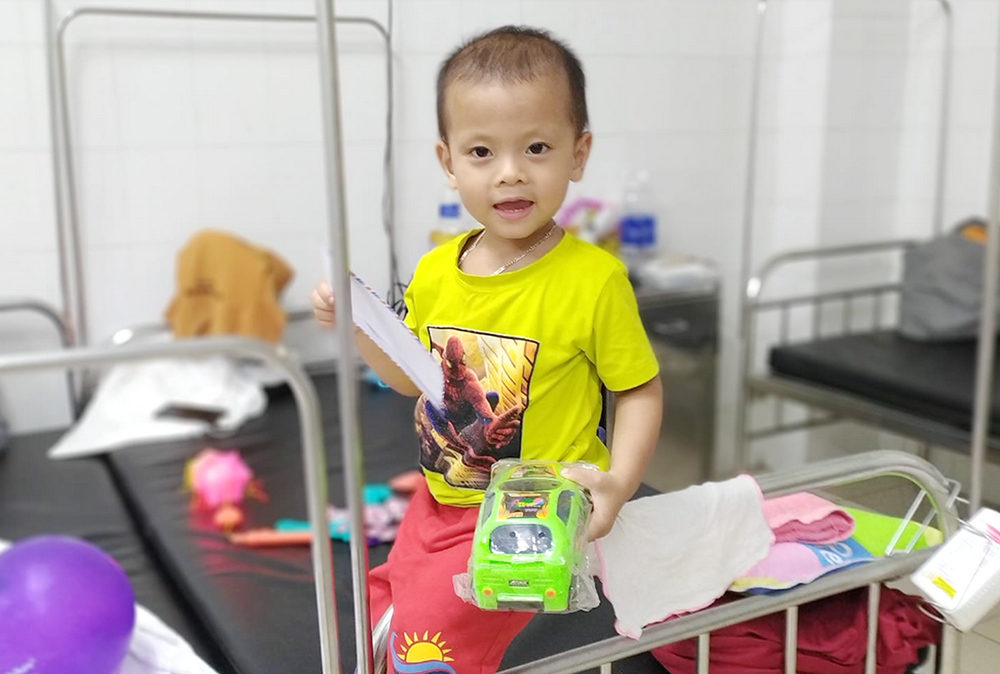 Le Gia Phuoc, a heart patient at Da Nang Hospital, is given money, a balloon, a toy and a lantern by the Daughters of Our Lady of the Visitation on Sept. 22. The nuns will cover part of the 2-year-old boy's medical treatment fees. (GSR photo/Joachim Pham)