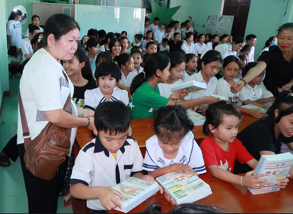 Missionaries of the Holy Cross Srs. Josephine Le Thi Phuong (left) and Martha Duong Thi Binh (right, in black) offer notebooks to 60 students on Sept. 22 in Da Nang. Floods had damaged their houses last year. "We try to help them to pursue their studies in the hard times, and that they will keep fond memories of this festival," Phuong said. (GSR photo/Joachim Pham)