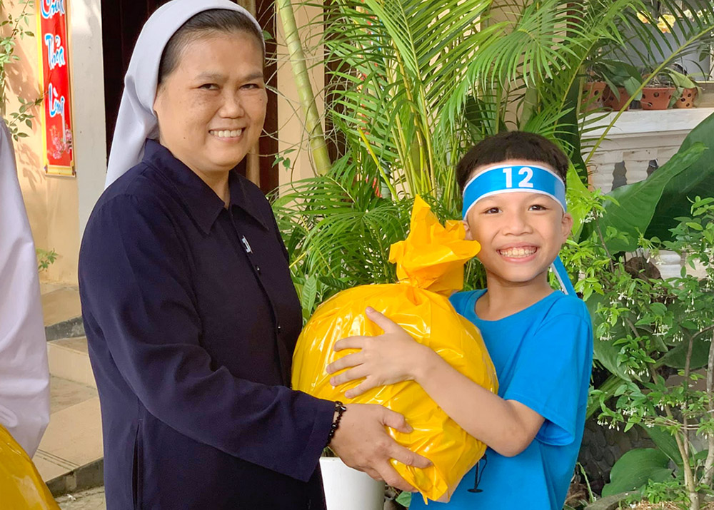 Missionaries of Charity Sr. Teresa Truong Thi Lam Hong gives gifts to a boy at Quang Ninh Convent in Quang Binh province Sept. 24. Hong said the nuns "give clothes, school bags and mooncakes to 50 children whose parents are drug abusers, prisoners and homeless people, so that they can celebrate the festival and integrate into society." (GSR photo/Joachim Pham)