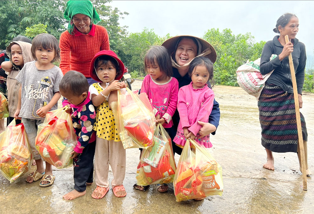 Ethnic Van Kieu children whose parents died of or were injured by ordnance left from wars receive gifts from Missionaries of Charity Sr. Margaret Vu Yen Nhung (wearing a conical hat) on Sept. 24 at Vinh Ha village in Quang Tri province. "This is the first time we offer gifts to the children who have no chance to get gifts to celebrate the festival because their parents have no money," Nhung said. (GSR photo/Joachim Pham)