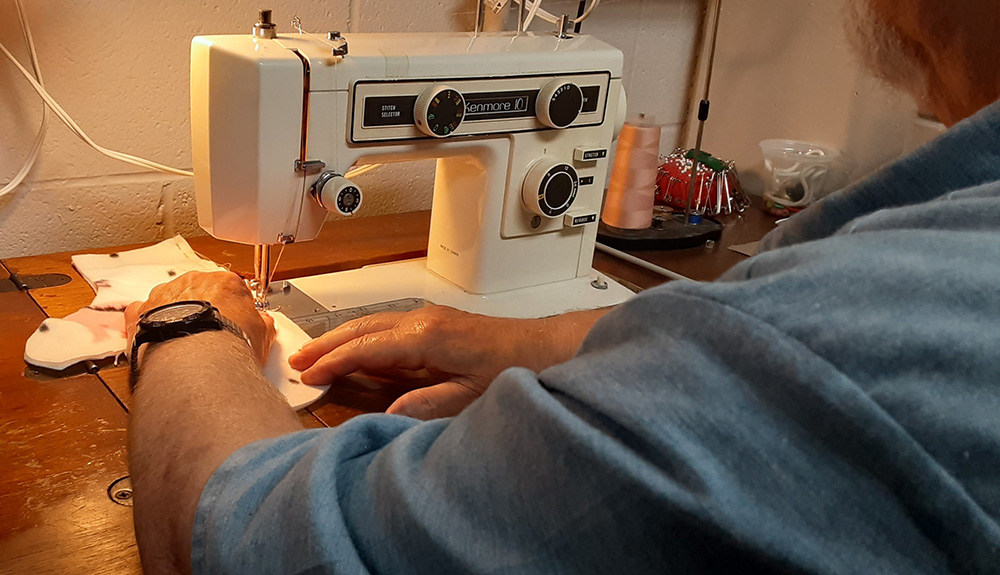 Joe, an inmate at the Grafton Correctional Institution, sews a mitten Aug. 28 that will be distributed through Catholic Charities of the Cleveland Diocese this winter. (Dennis Sadowski)