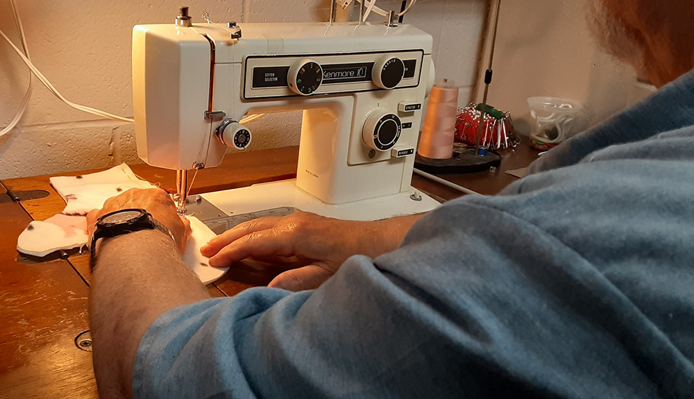 Joe, an inmate at the Grafton Correctional Institution, sews a mitten Aug. 28 that will be distributed through Catholic Charities of the Cleveland Diocese this winter. (Dennis Sadowski)